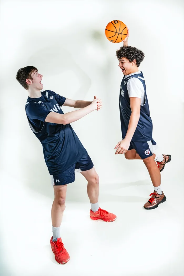 Two MVE teammates laughing as one balances a basketball on his head at 2026 Media Day